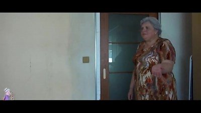 A chubby older woman engages in sexual activity with a younger female partner