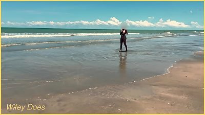 A wife goes topless and plays football in public on a beach while clothed